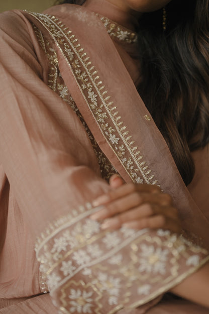 Close-up of a person wearing a traditional outfit with intricate embroidery.
